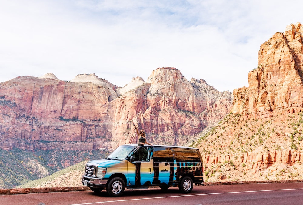 Girl sitting on top of van in Zion National Park
