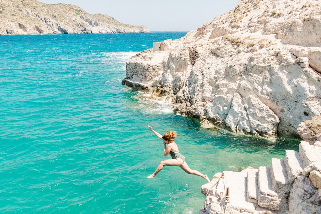 girl jumping off stairs in Greece