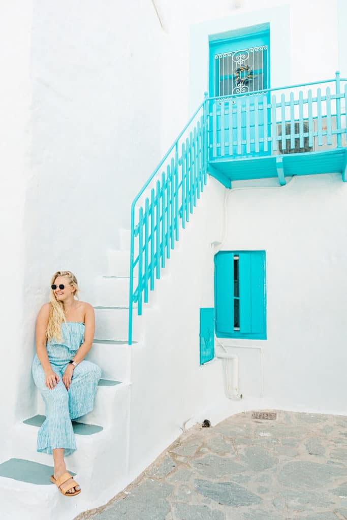 girl sitting on blue steps in Greece