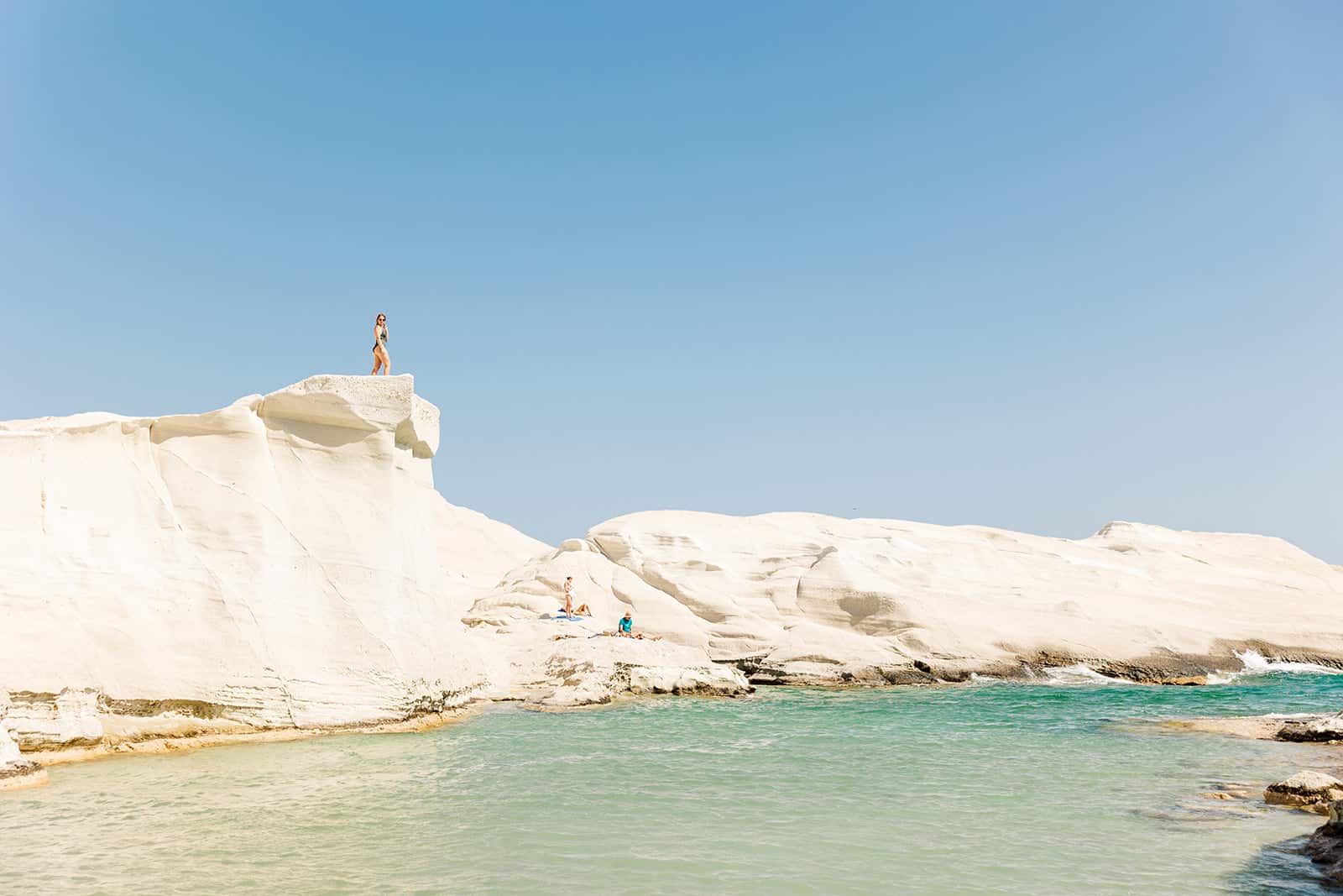 girl sitting atop giant rock in Sarakiniko Beach Milos Greece