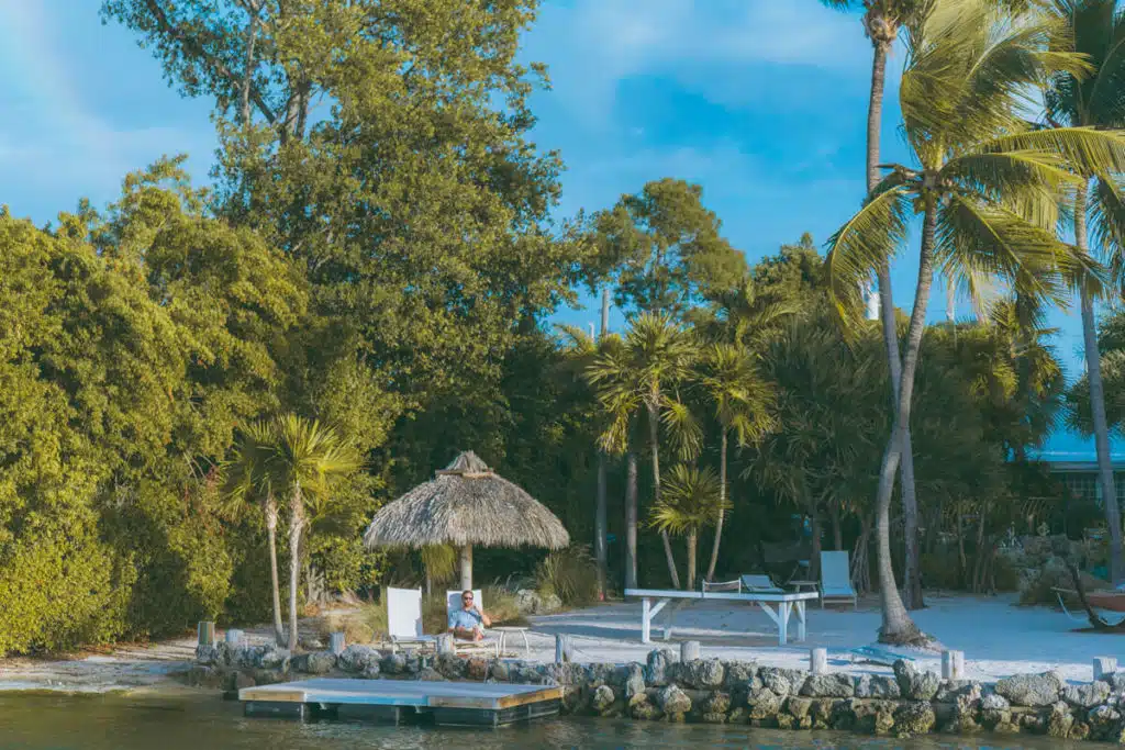 man sitting under tiki hut