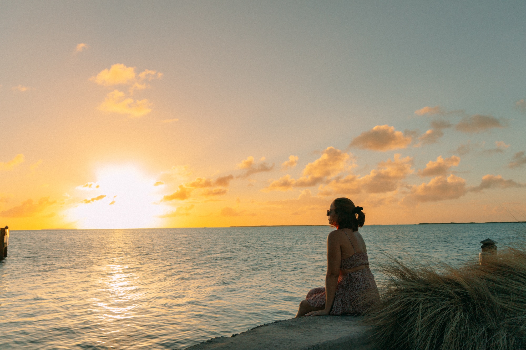 Girl sitting in front of sunset