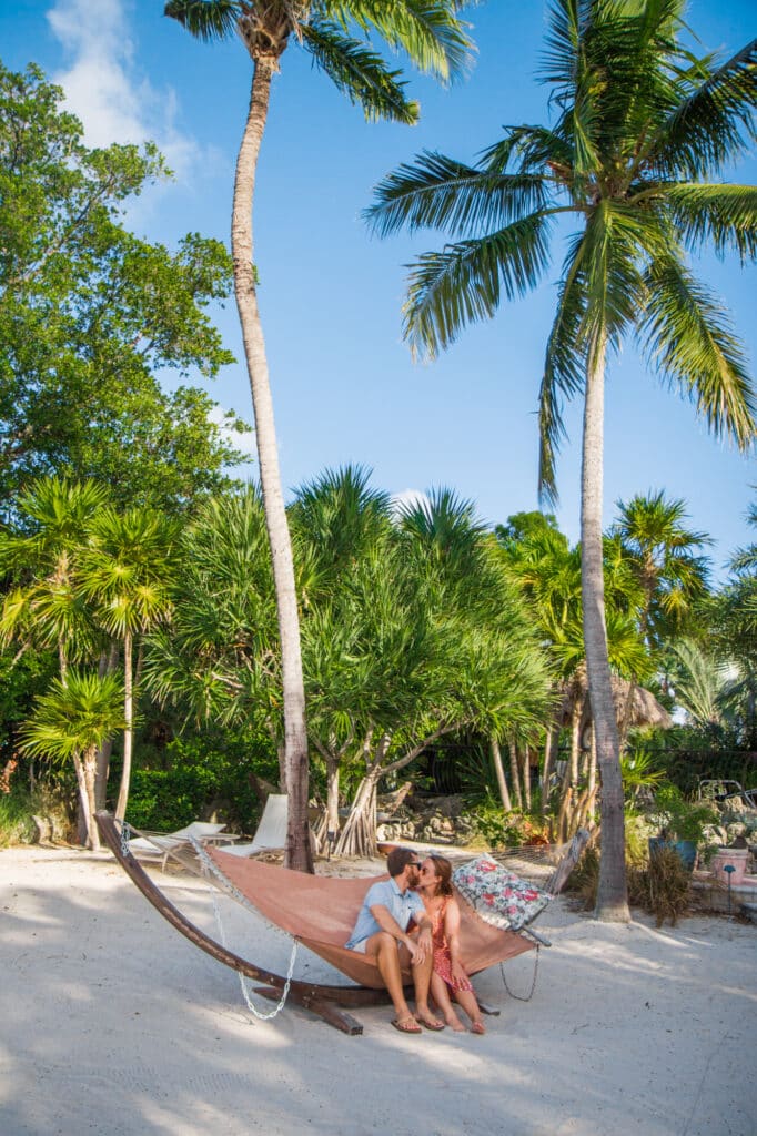 Man and woman sitting on hammock in tropical paradise
