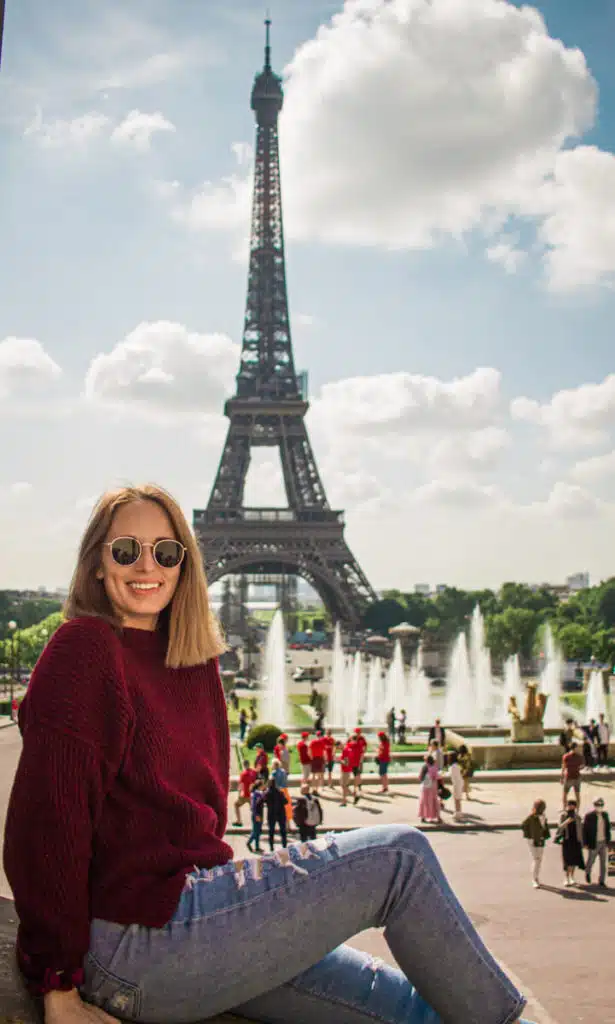 girl sitting in front of Eiffel Tower in Paris