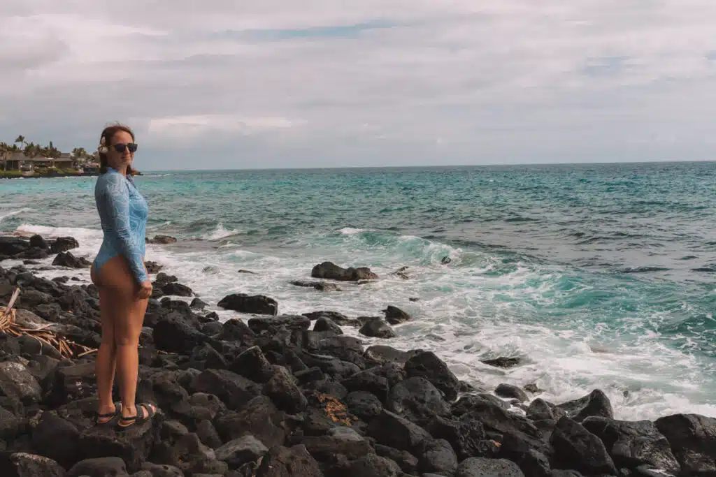 girl standing on black lava rocks in Hawaii
