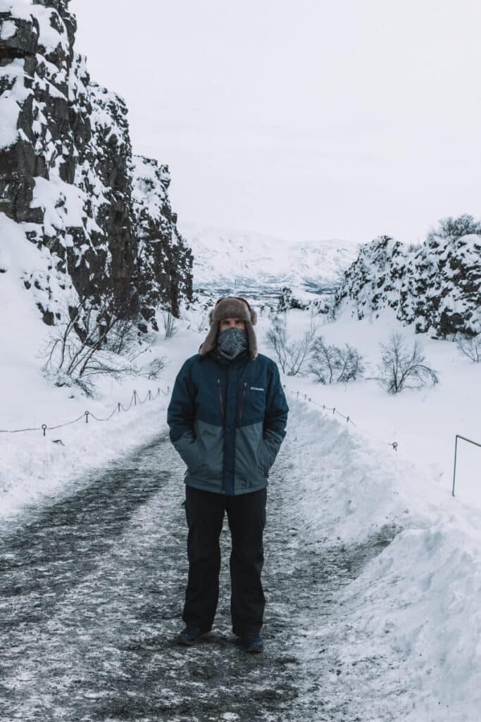 man standing in thingvellir national park in winter in iceland