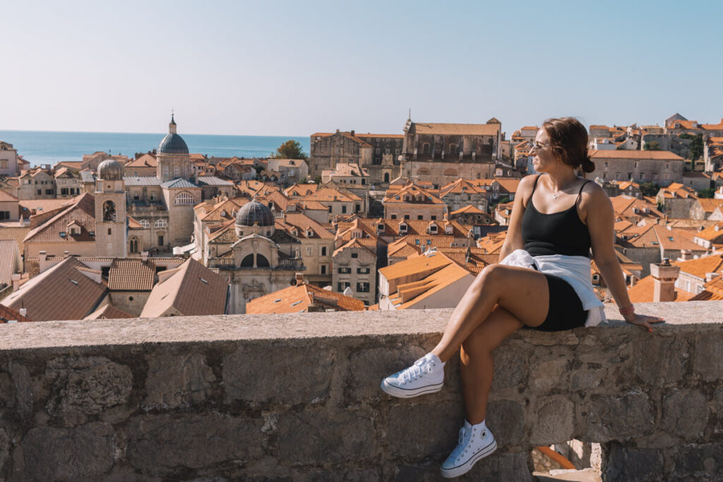 girl sitting on wall in Dubrovnik, Croatia