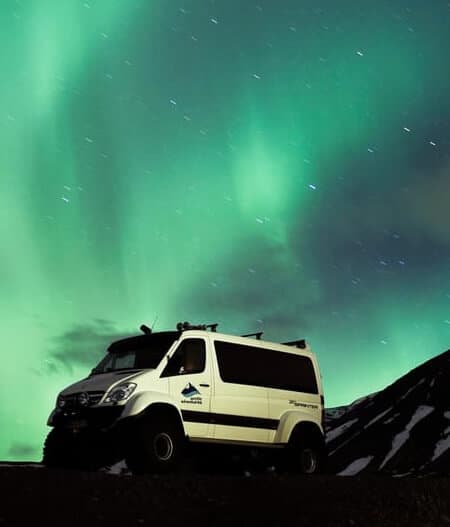Arctic Adventures bus with Northern Lights in the background