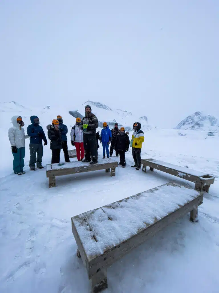 group of people around snow-covered benches on their way to the Katla Ice Cave in Iceland
