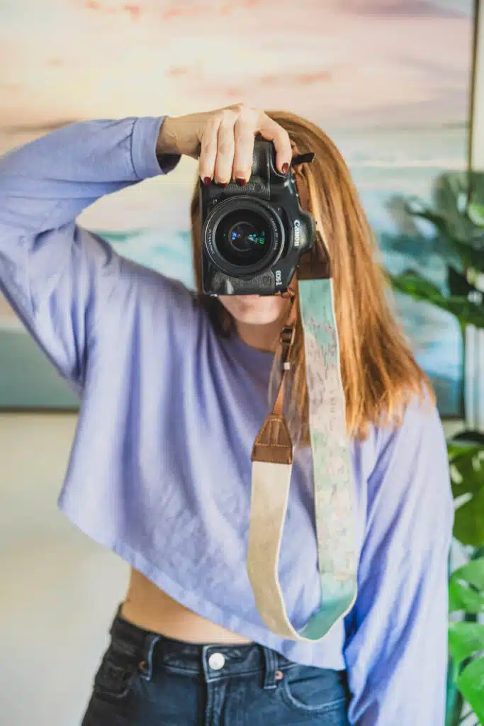 girl in purple shirt holding a camera up to her eye