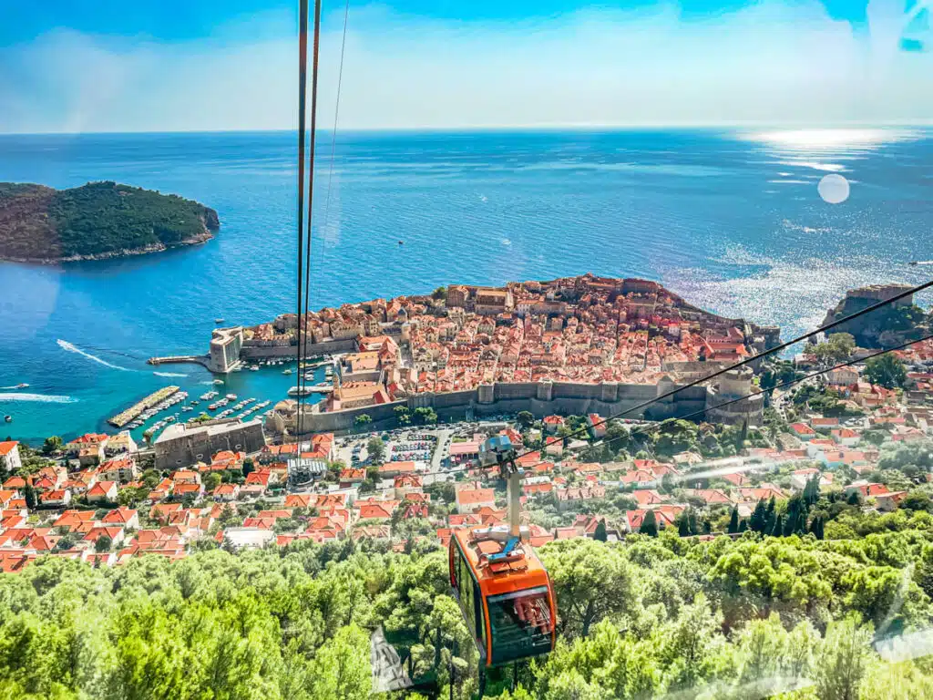 view of Dubrovnik and Adriatic Sea with Mount Srd Cable car in foreground. Riding the cable car is one of the coolest things to do in Dubrovnik, Croatia!
