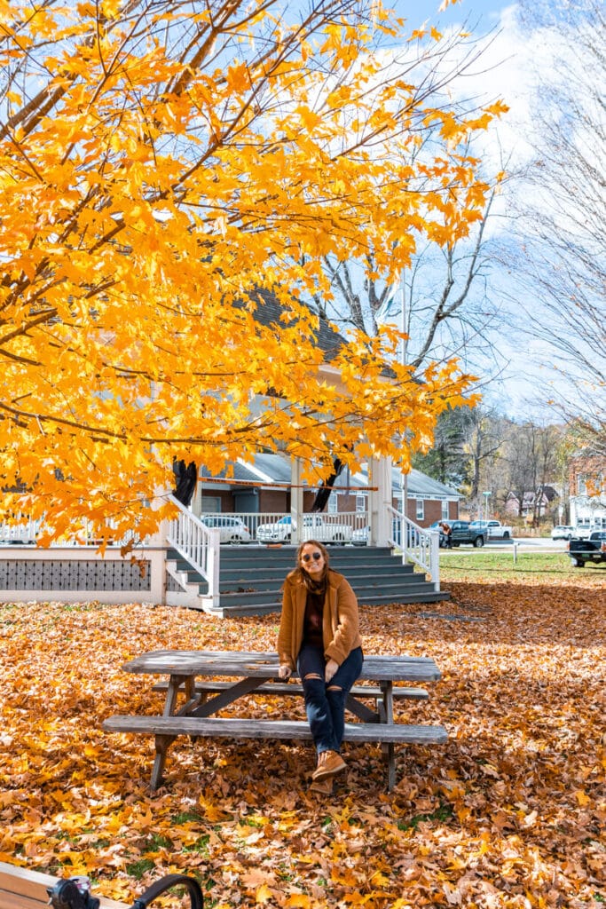 girl sitting on picnic table under orange tree in South Royalton, Vermont