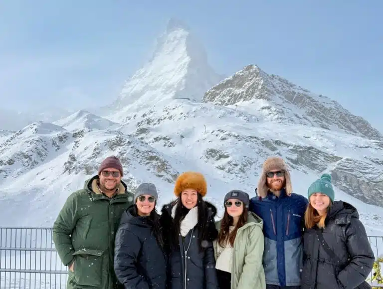 group of friends in winter outfits in front of snowy matterhorn during Switzerland in December