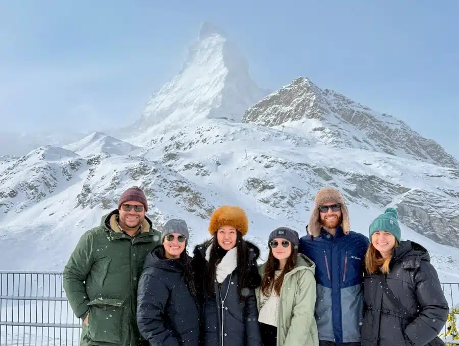 group of friends in winter outfits in front of snowy matterhorn during Switzerland in December