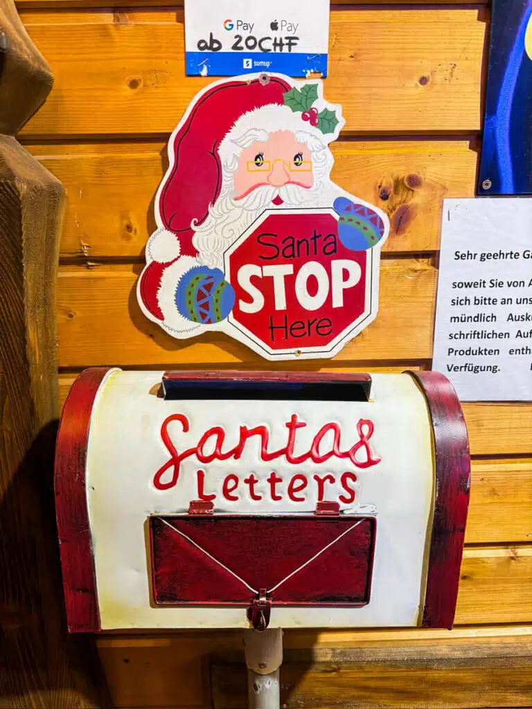 Santa’s Letters mailbox under a “Santa Stop Here” sign at a wooden stall at the Basel Barfusserplatz Christmas market