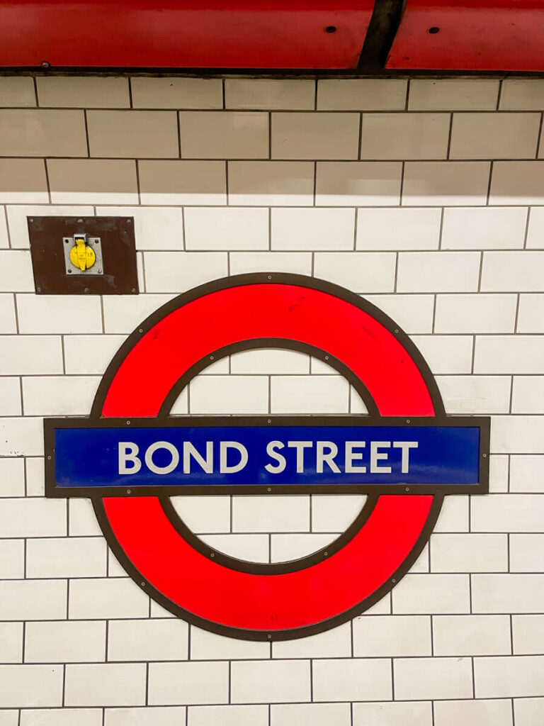 London Underground roundel sign for Bond Street station on a white tiled wall